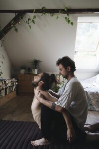 Zdjęcie przedstawia Tomka Raszewskiego - masażystę z wieloletnim doświadczeniem oraz właściciela Mahasanti.pl, który prowadzi sesję ajurwedyjskiego masażu jogicznego wprowadzając klienta w jogiczne odgięcie otwierające jego klatkę piersiową.